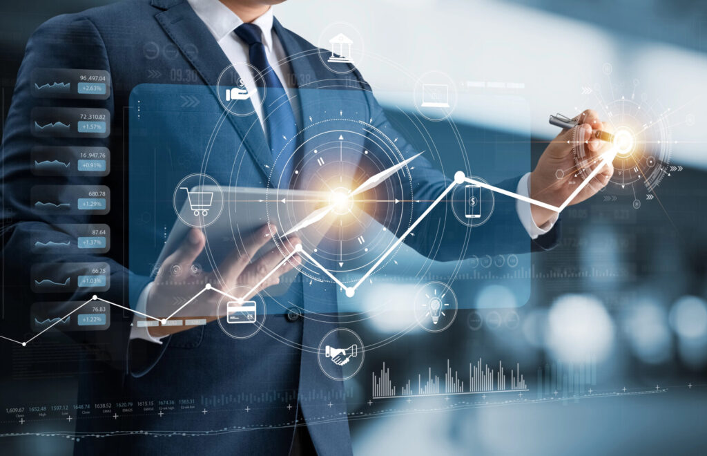 Businessmann tippt auf digitale Wachstumskurve, darüber ein Kompass, dessen Nadel parallel zum Graphen nach rechts oben zeigt